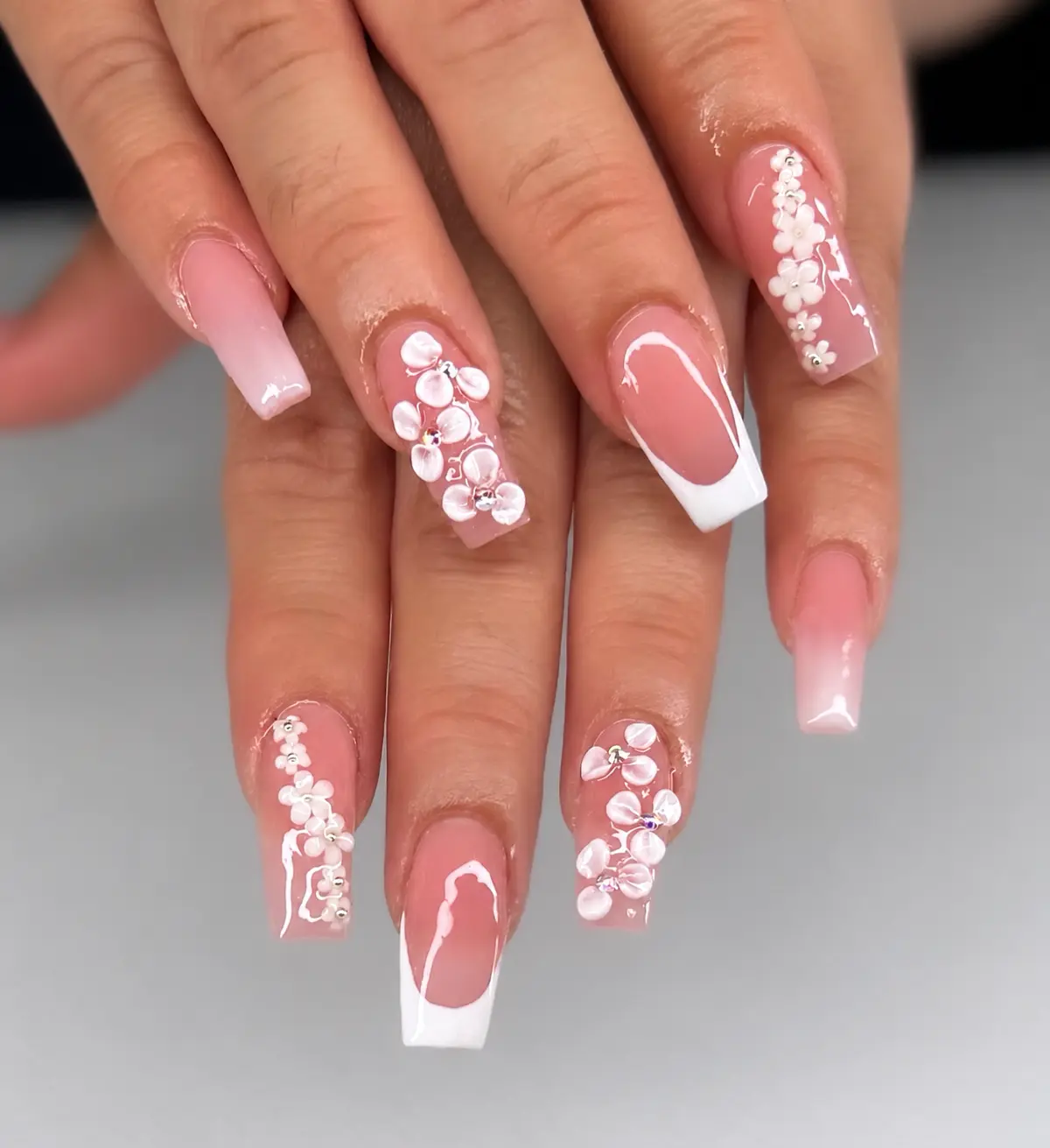 Pink and white square French nails with sculpted white flowers