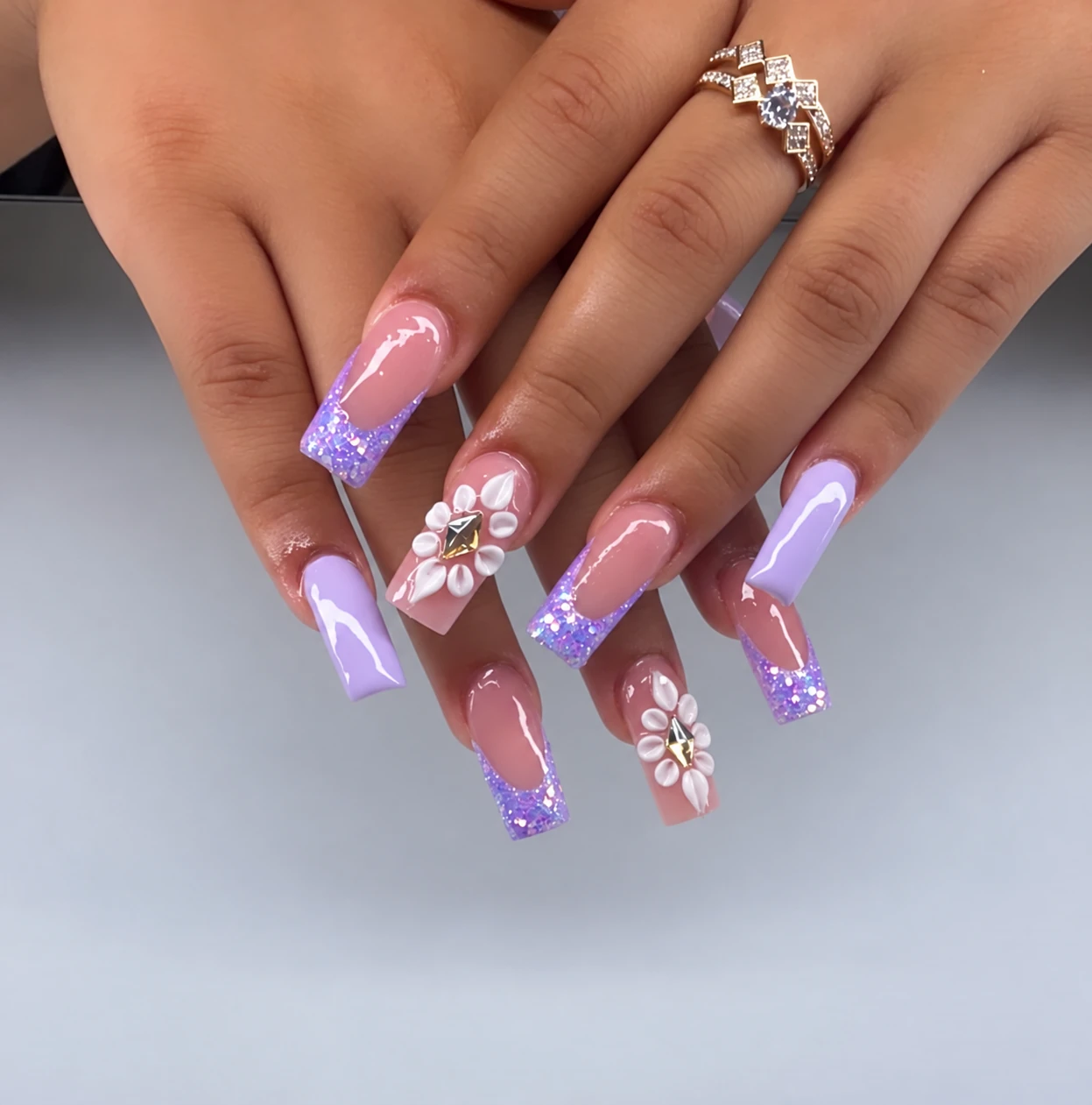 Lavender glitter tips and white floral art by Elasc Nails