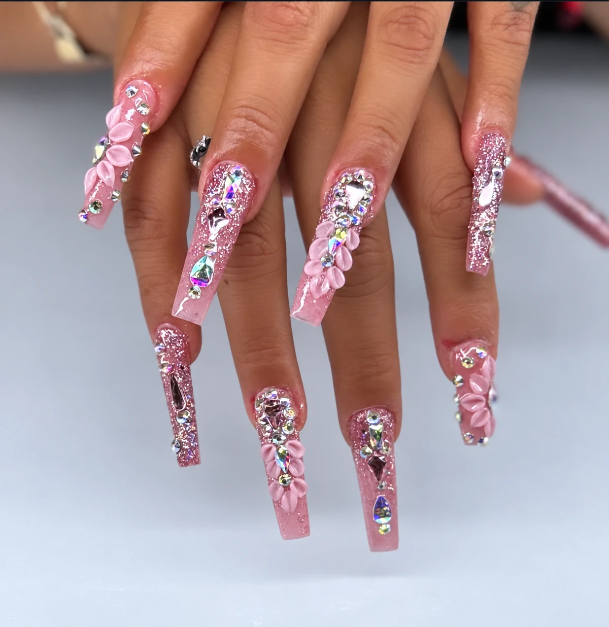 Pink nails with rhinestones and sculpted flowers
