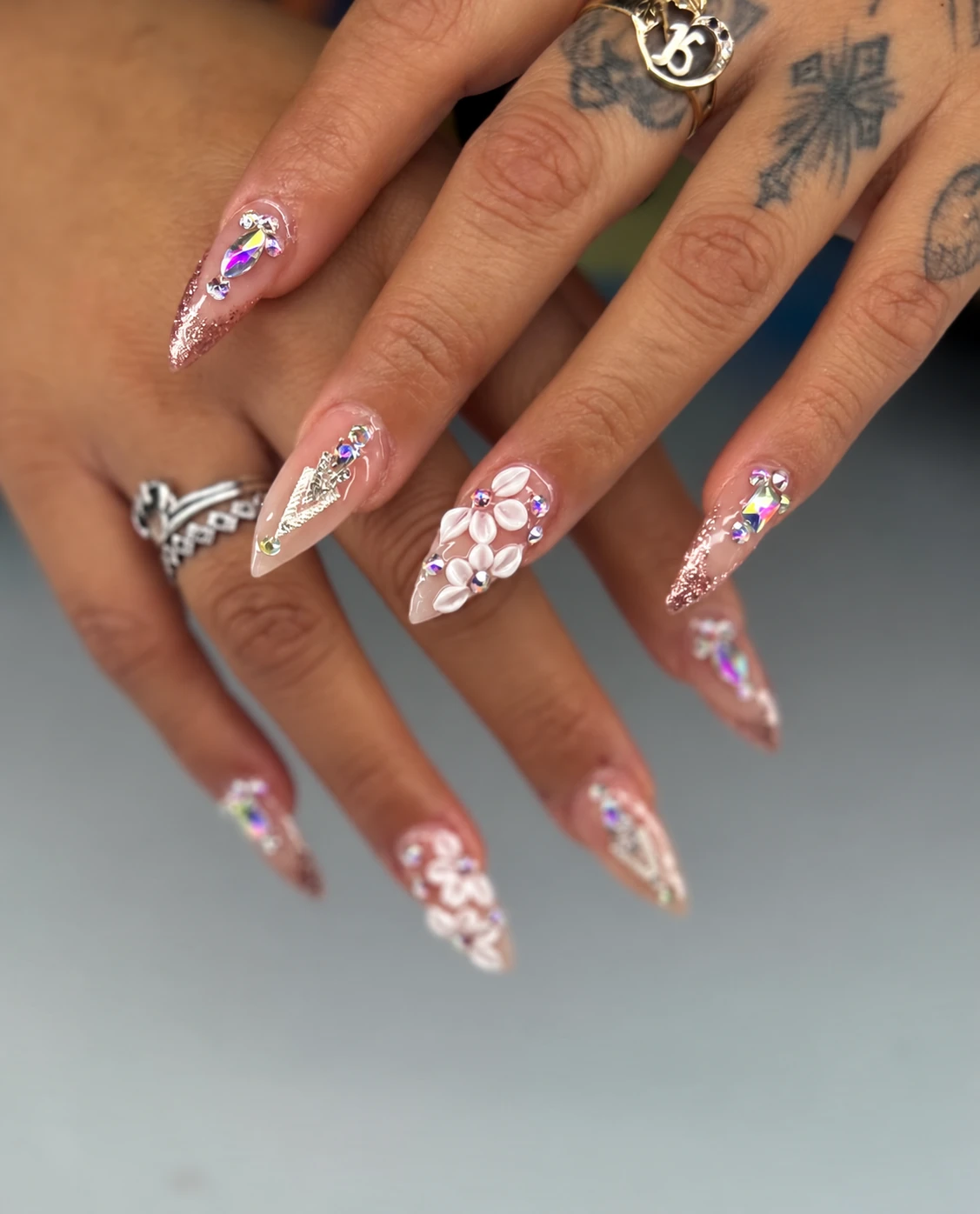 Elasc stiletto nails with white floral art and rhinestones